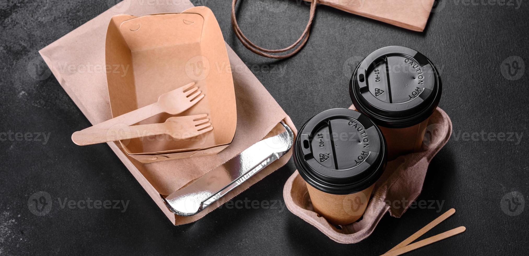 Disposable dishes made of environmentally friendly brown cardboard on a dark background photo