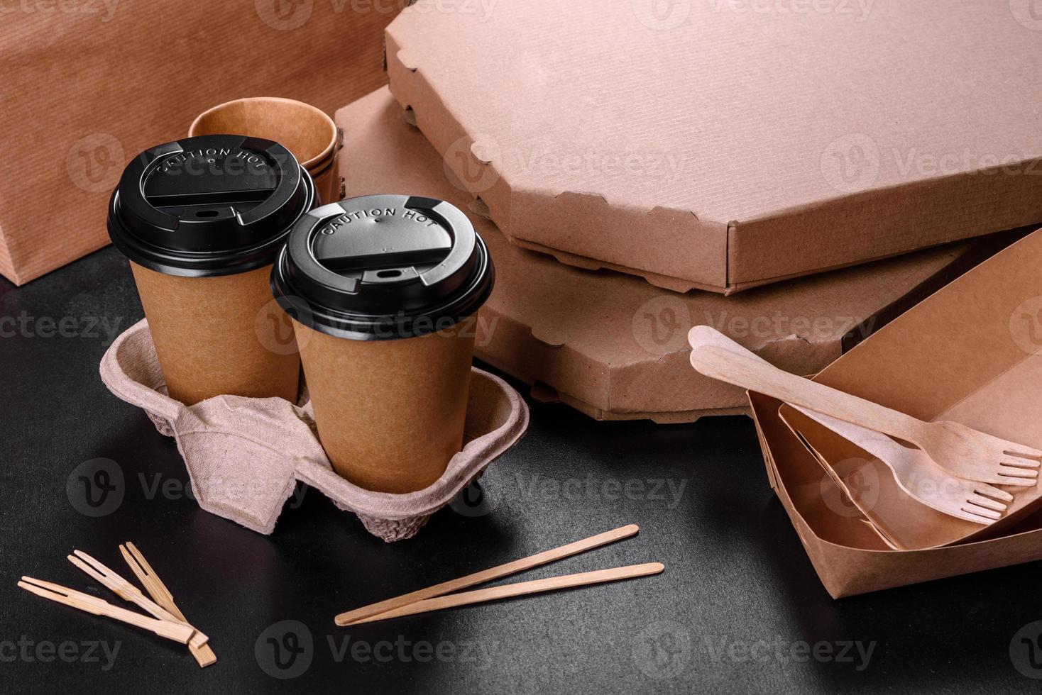 Disposable dishes made of environmentally friendly brown cardboard on a dark background photo