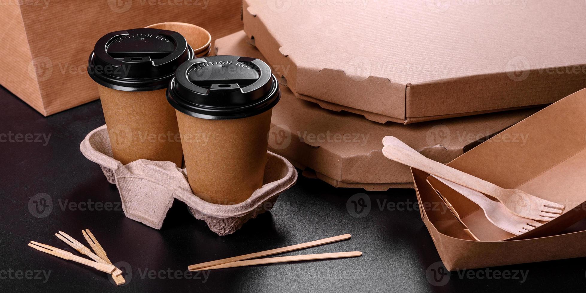 Disposable dishes made of environmentally friendly brown cardboard on a dark background photo