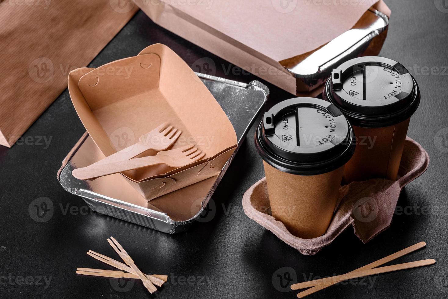 Disposable dishes made of environmentally friendly brown cardboard on a dark background photo