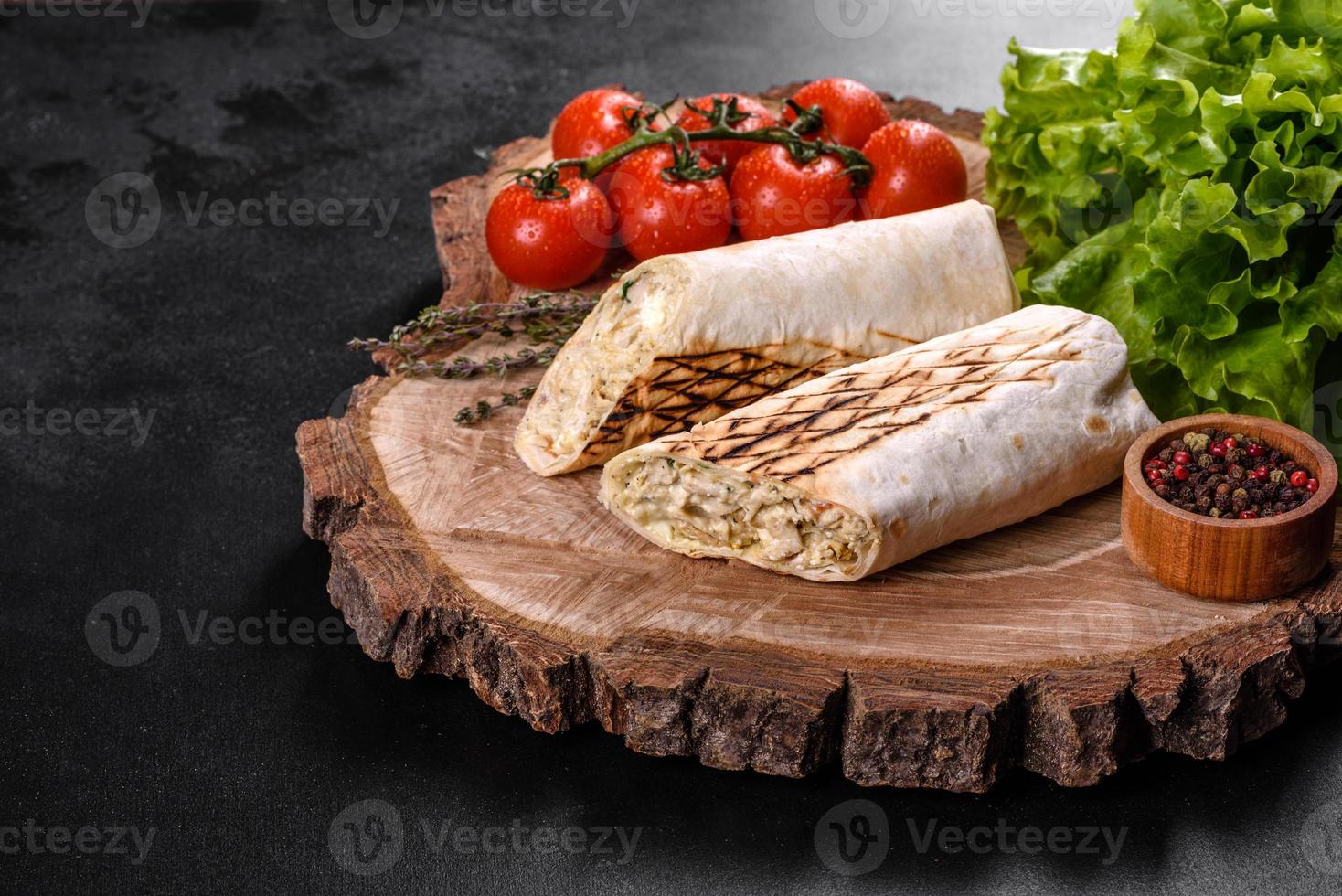 Delicioso shawarma fresco con carne y verduras sobre una mesa de hormigón oscuro foto