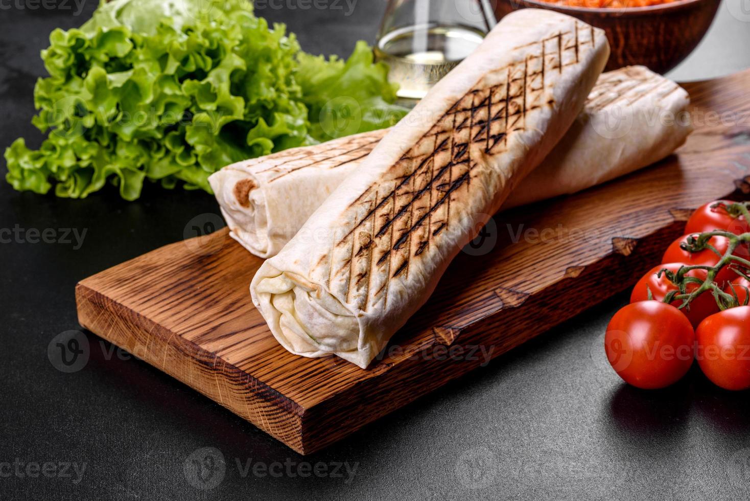 Delicioso shawarma fresco con carne y verduras sobre una mesa de hormigón oscuro foto