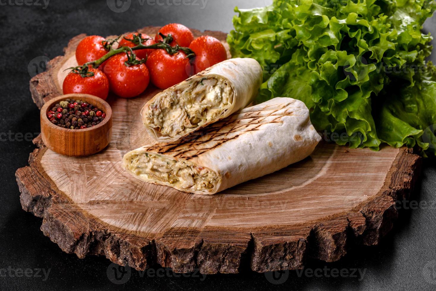Delicioso shawarma fresco con carne y verduras sobre una mesa de hormigón oscuro foto