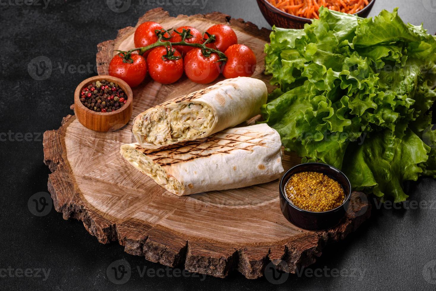 Delicious fresh shawarma with meat and vegetables on a dark concrete table photo