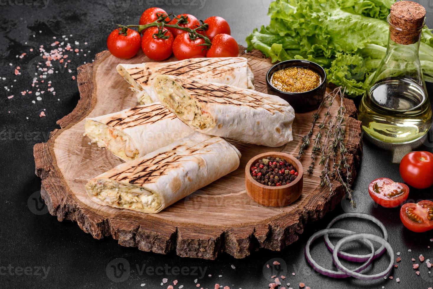 Delicious fresh shawarma with meat and vegetables on a dark concrete table photo