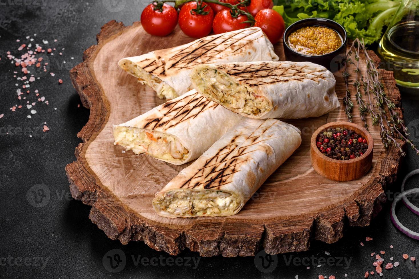 Delicioso shawarma fresco con carne y verduras sobre una mesa de hormigón oscuro foto