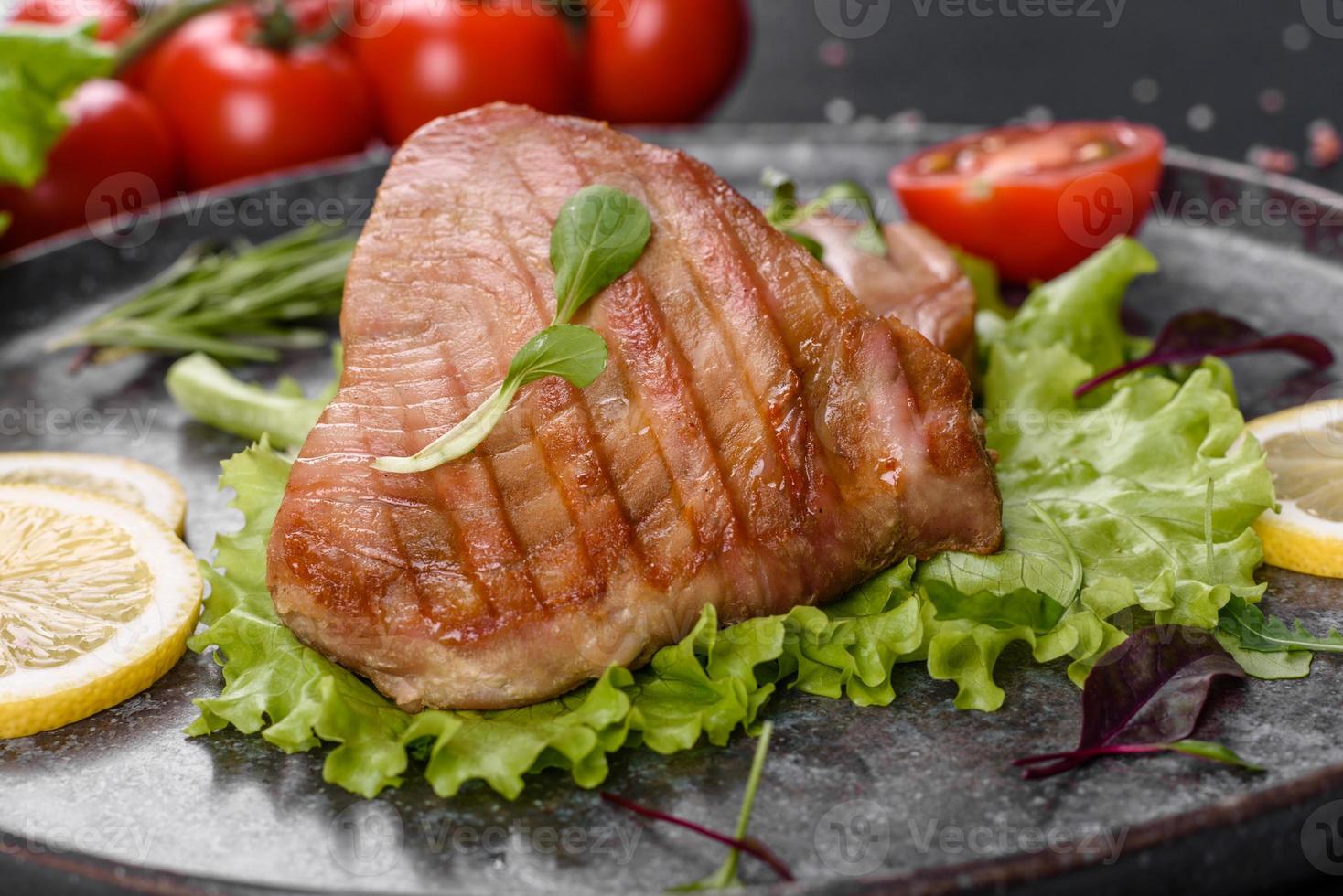 Delicious juicy tuna steak grilled with spices and herbs photo