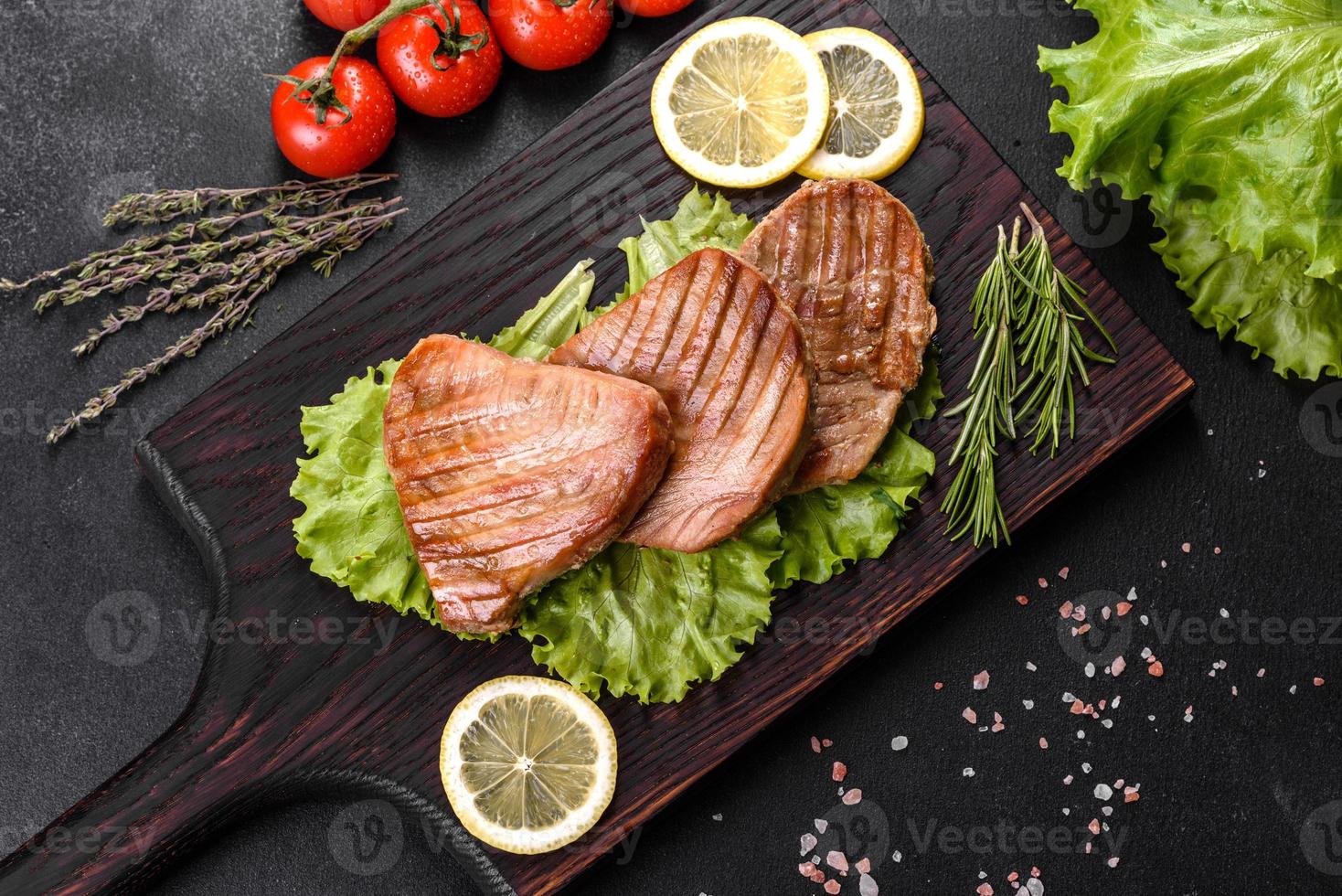 Delicious juicy tuna steak grilled with spices and herbs photo