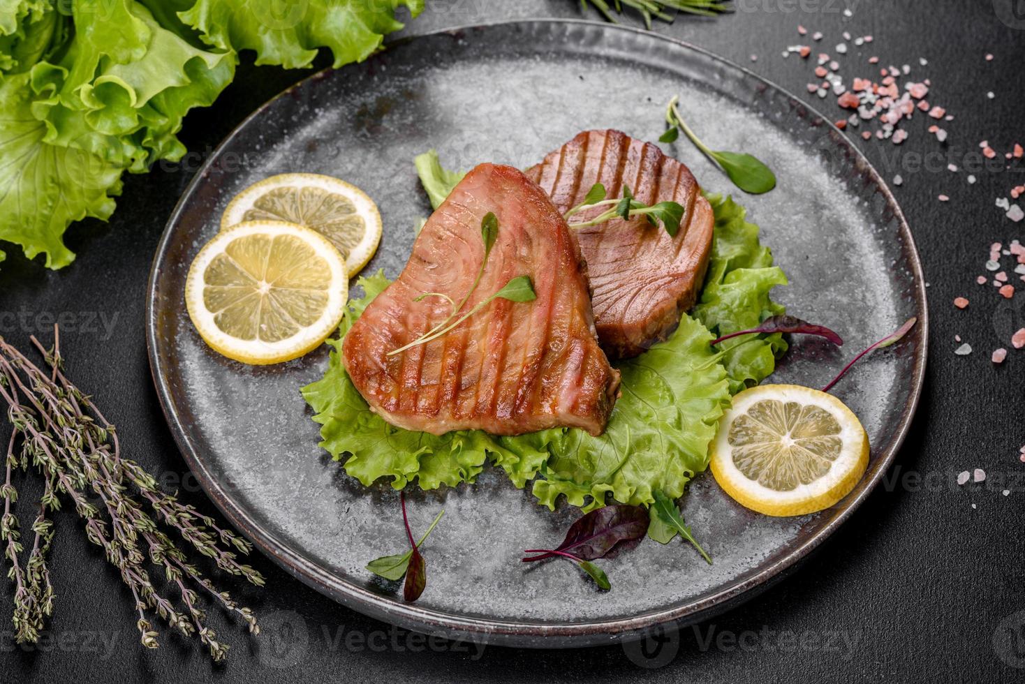 Delicious juicy tuna steak grilled with spices and herbs photo