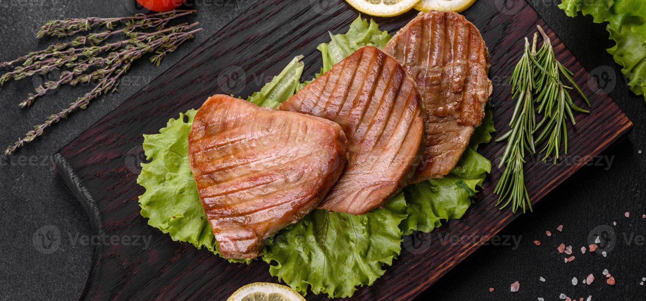 Delicioso y jugoso filete de atún a la parrilla con especias y hierbas. foto