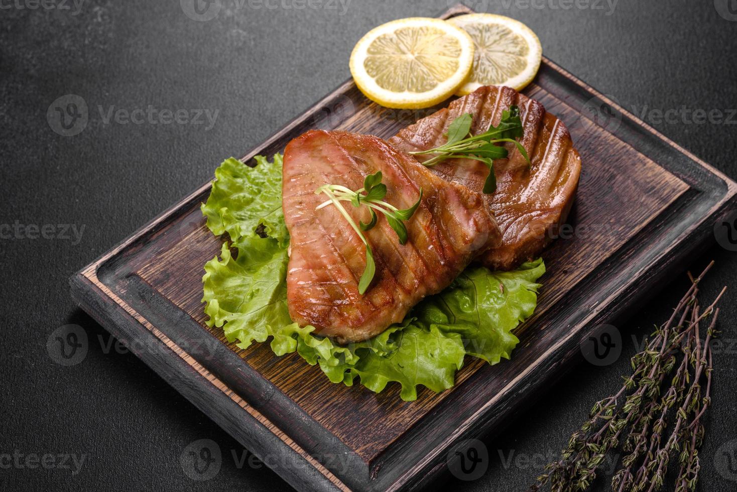 Delicious juicy tuna steak grilled with spices and herbs photo