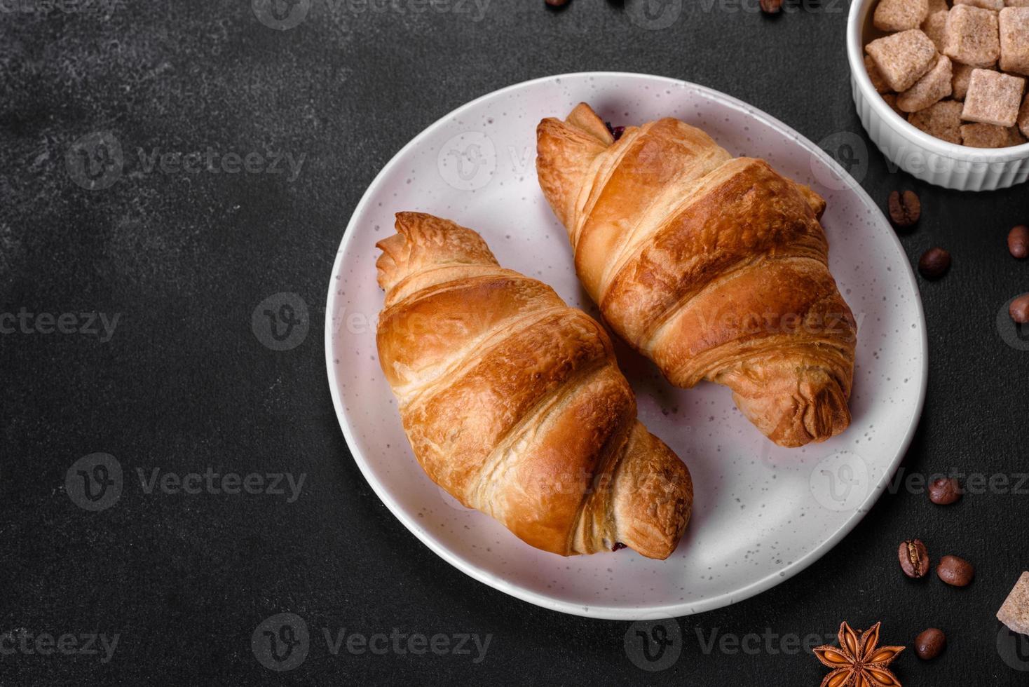 delicioso croissant francés fresco y crujiente con una taza de café aromático foto