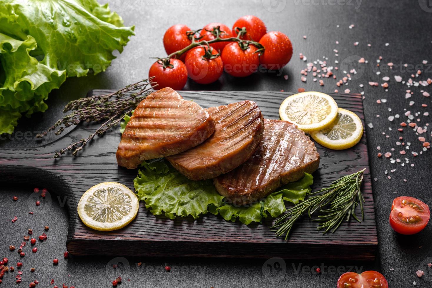 Delicious juicy tuna steak grilled with spices and herbs photo