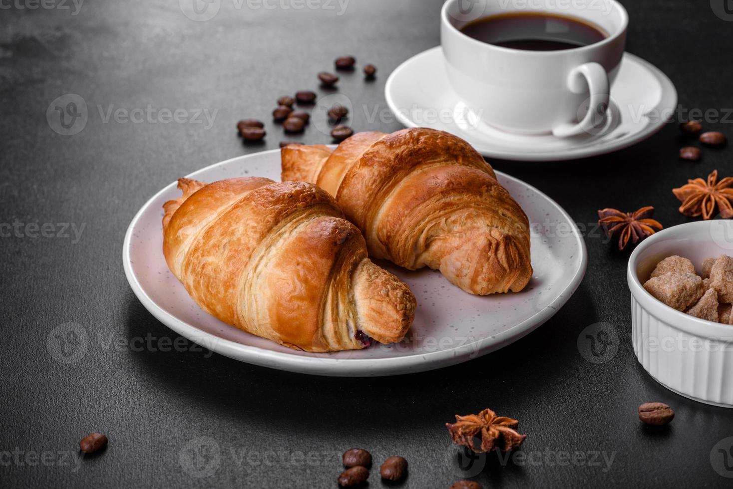 delicioso croissant francés fresco y crujiente con una taza de café aromático foto