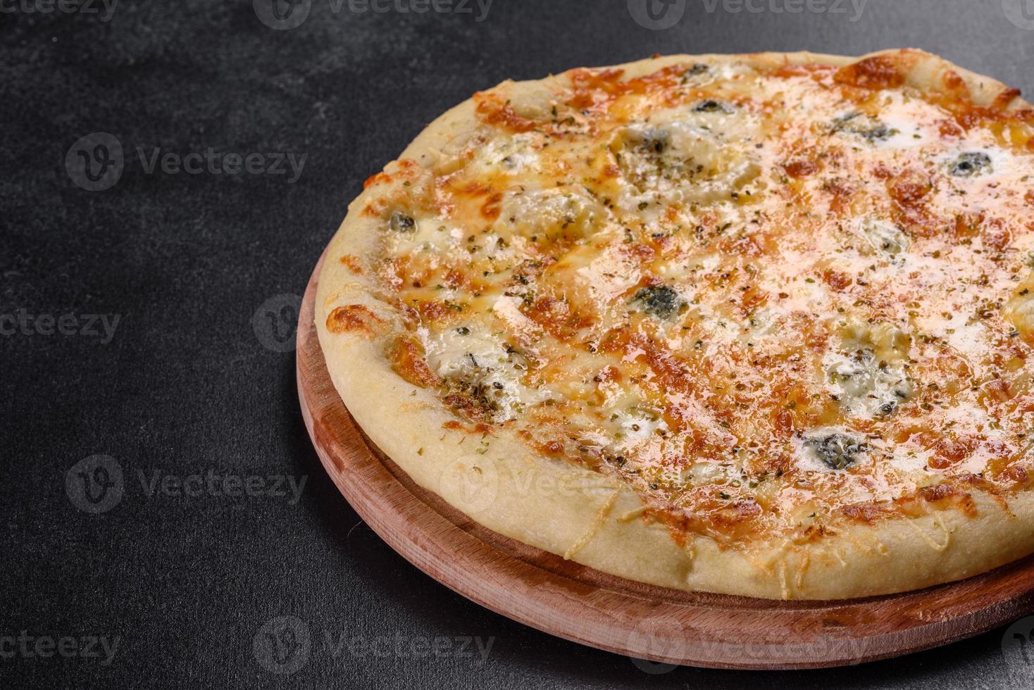 Sabrosa pizza fresca al horno con tomates, queso y champiñones sobre un fondo de hormigón oscuro foto