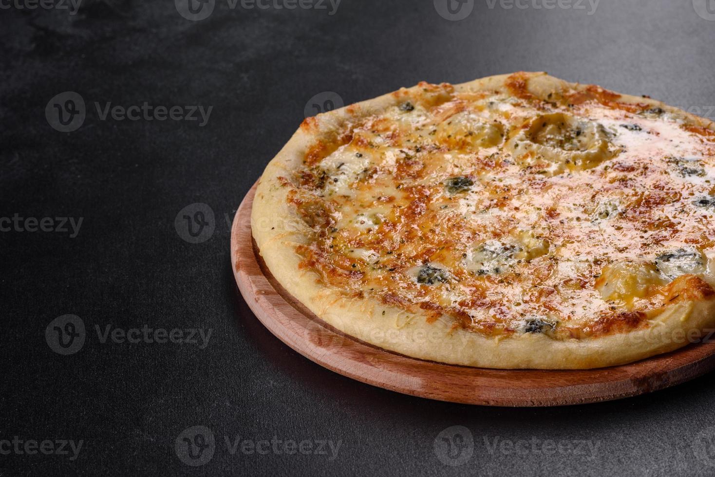 Tasty fresh oven pizza with tomatoes, cheese and mushrooms on a dark concrete background photo