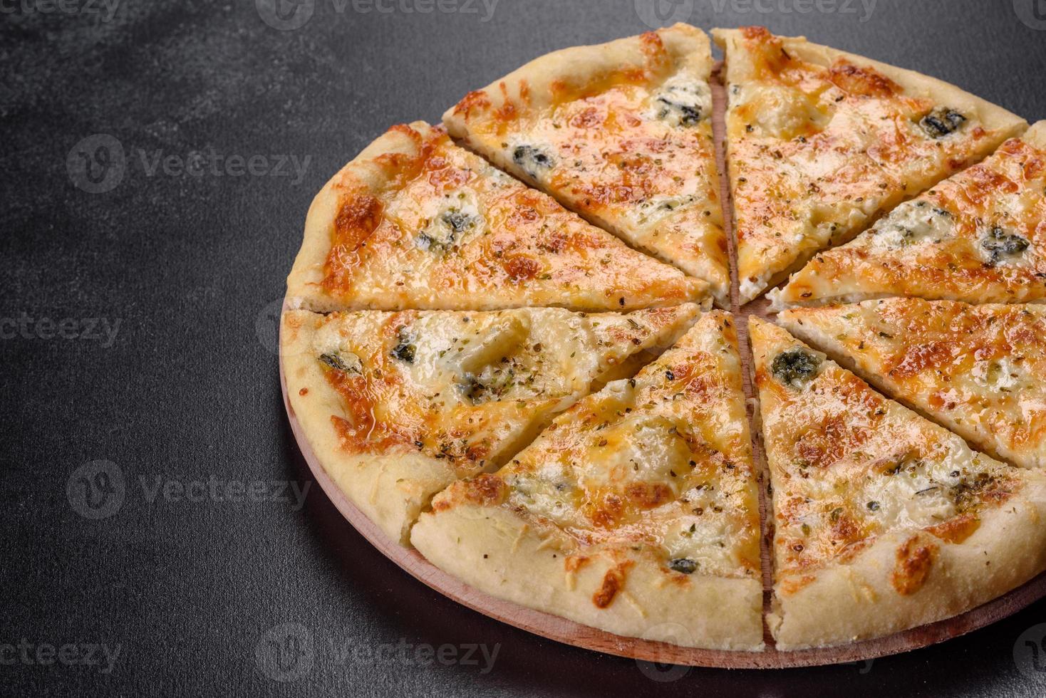 Sabrosa pizza fresca al horno con tomates, queso y champiñones sobre un fondo de hormigón oscuro foto