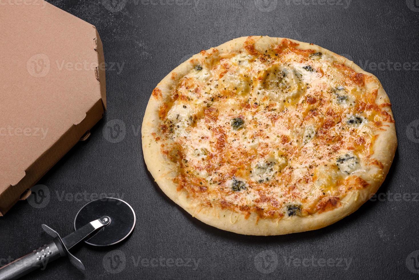 Tasty fresh oven pizza with tomatoes, cheese and mushrooms on a dark concrete background photo