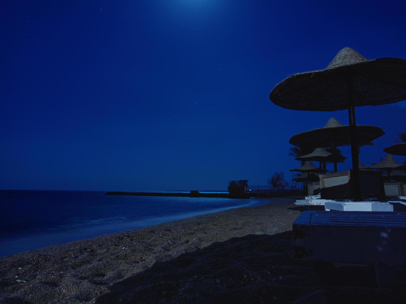 tarde en la playa con sombrillas de paja. Hurghada, Egipto foto