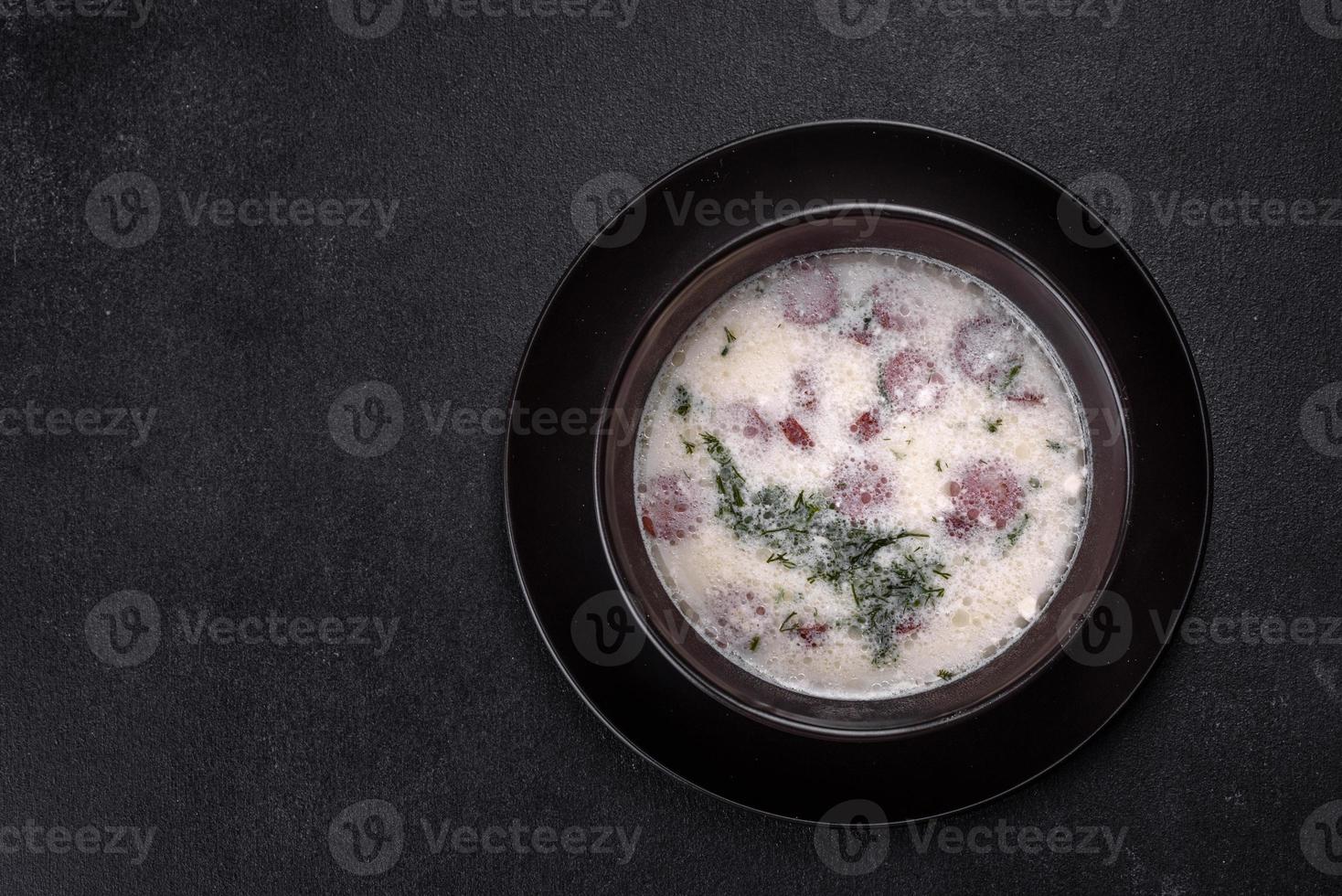 sopa de queso con salchichas fritas y hierbas. sabrosa sopa de queso crema foto