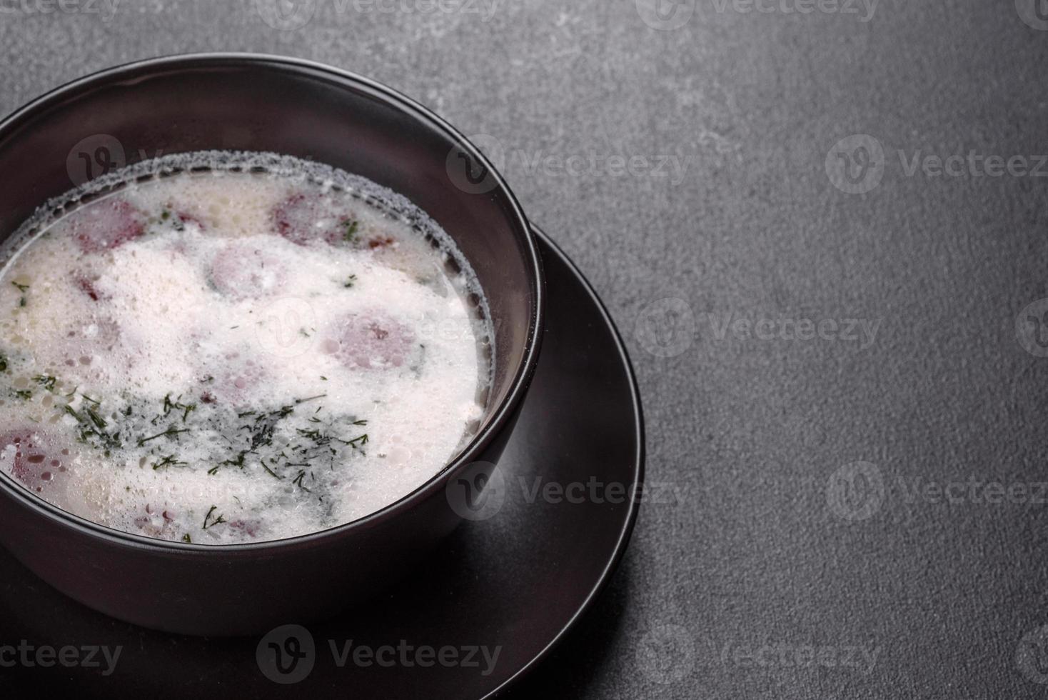 sopa de queso con salchichas fritas y hierbas. sabrosa sopa de queso crema foto