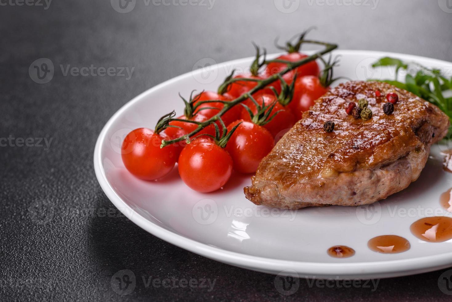 Baked duck breast with herbs and spices on a dark concrete background photo