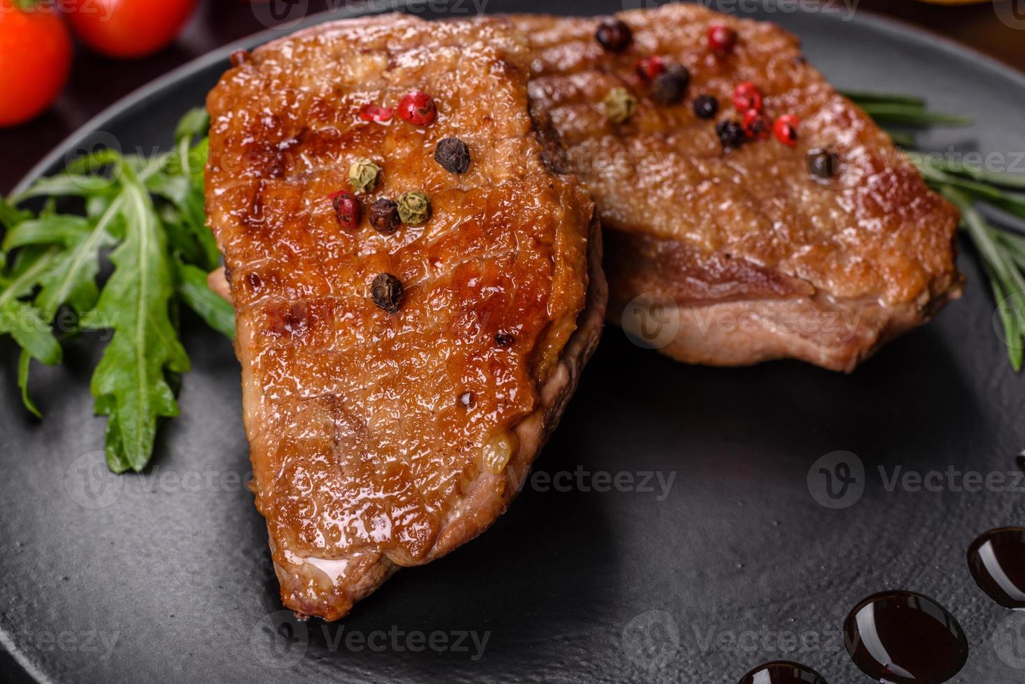 Baked duck breast with herbs and spices on a dark concrete background
