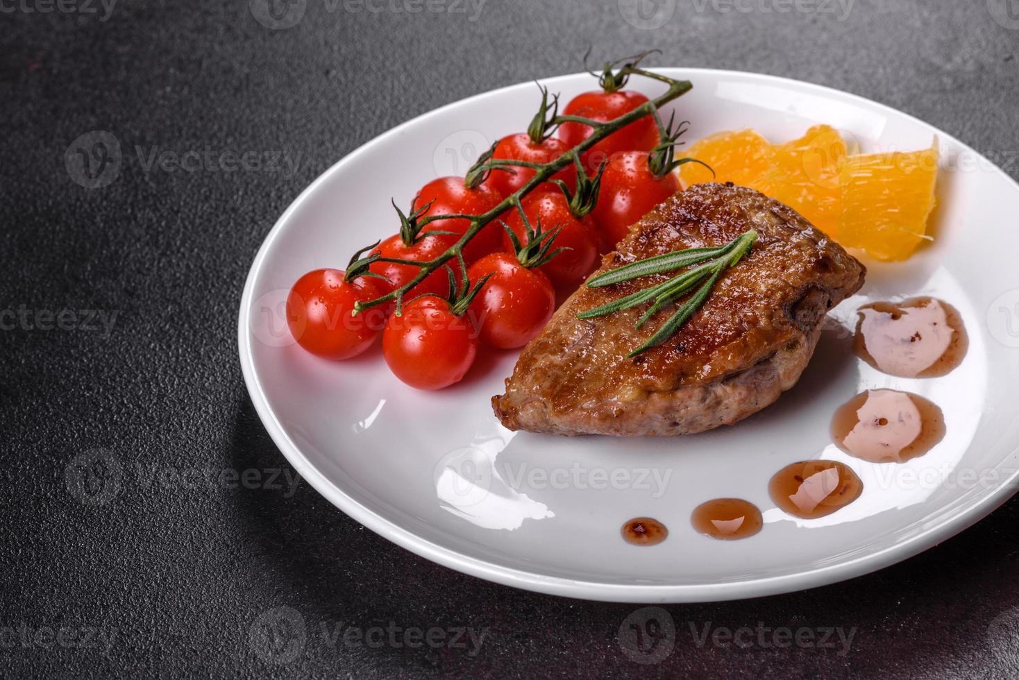 Baked duck breast with herbs and spices on a dark concrete background photo