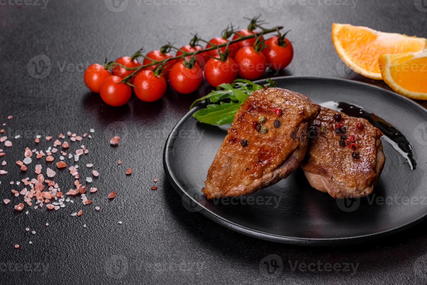 Baked duck breast with herbs and spices on a dark concrete background photo