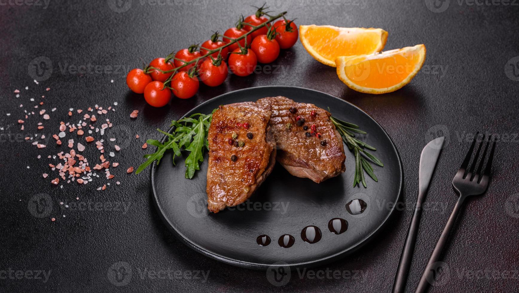 Baked duck breast with herbs and spices on a dark concrete background