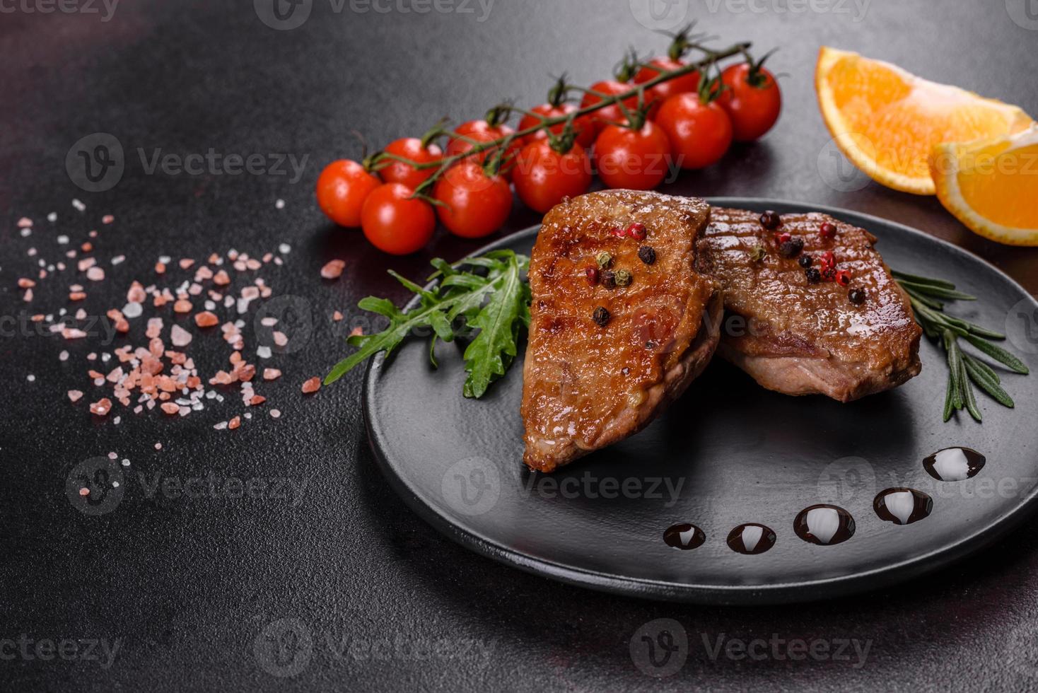 Baked duck breast with herbs and spices on a dark concrete background photo
