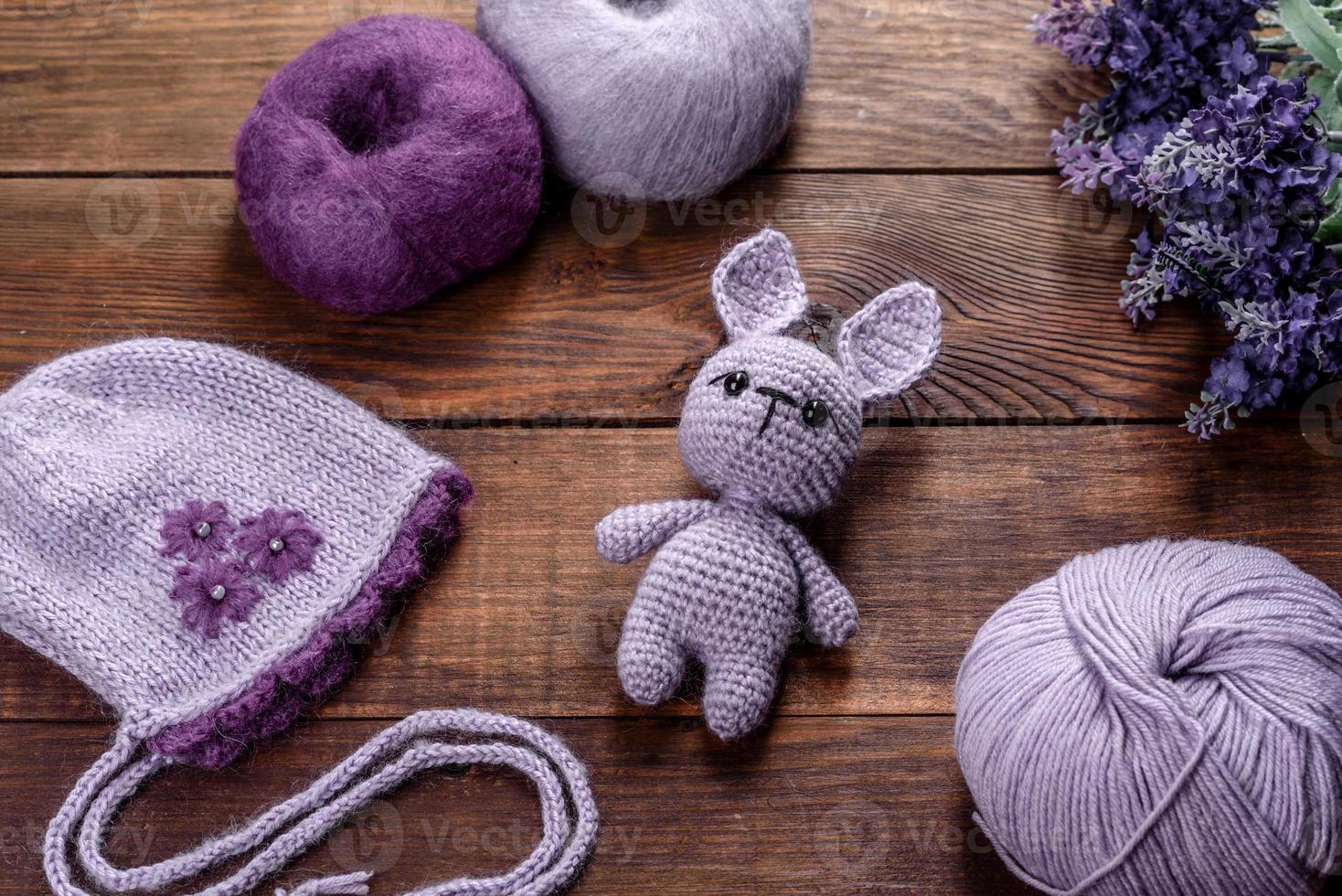 Toy hare tied from woolen threads on a dark background photo