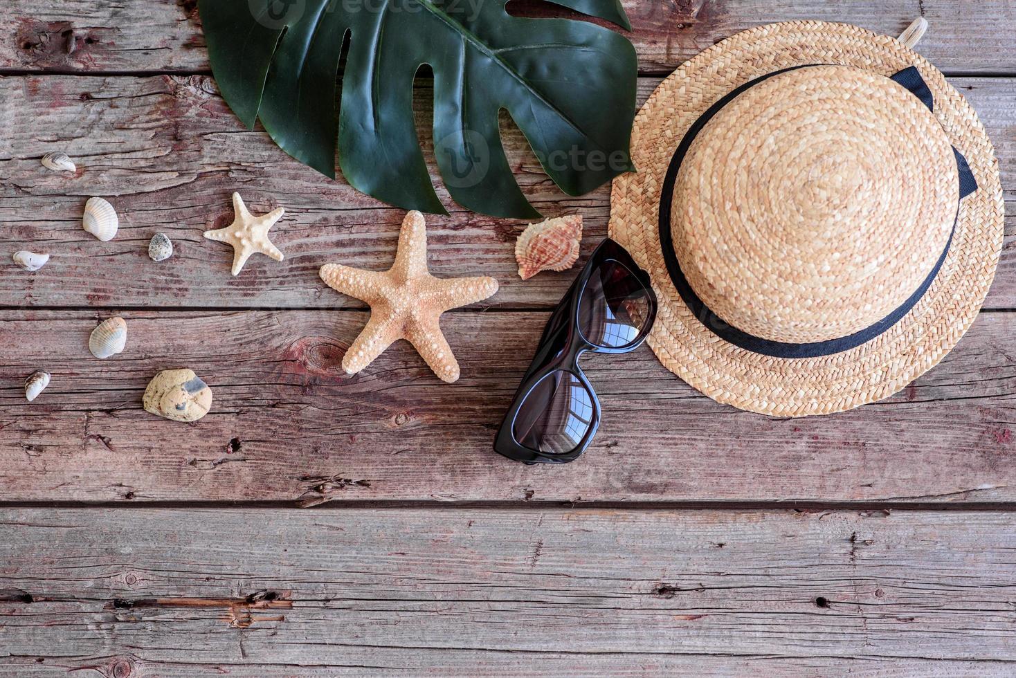 Glasses and hat with shells and sea stars on a colored background photo