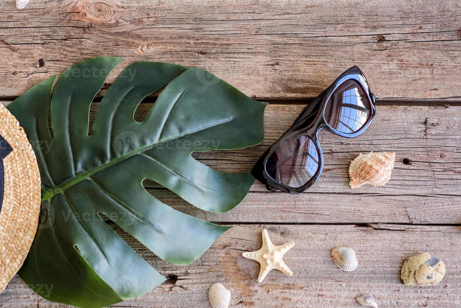 Glasses and hat with shells and sea stars on a colored background photo