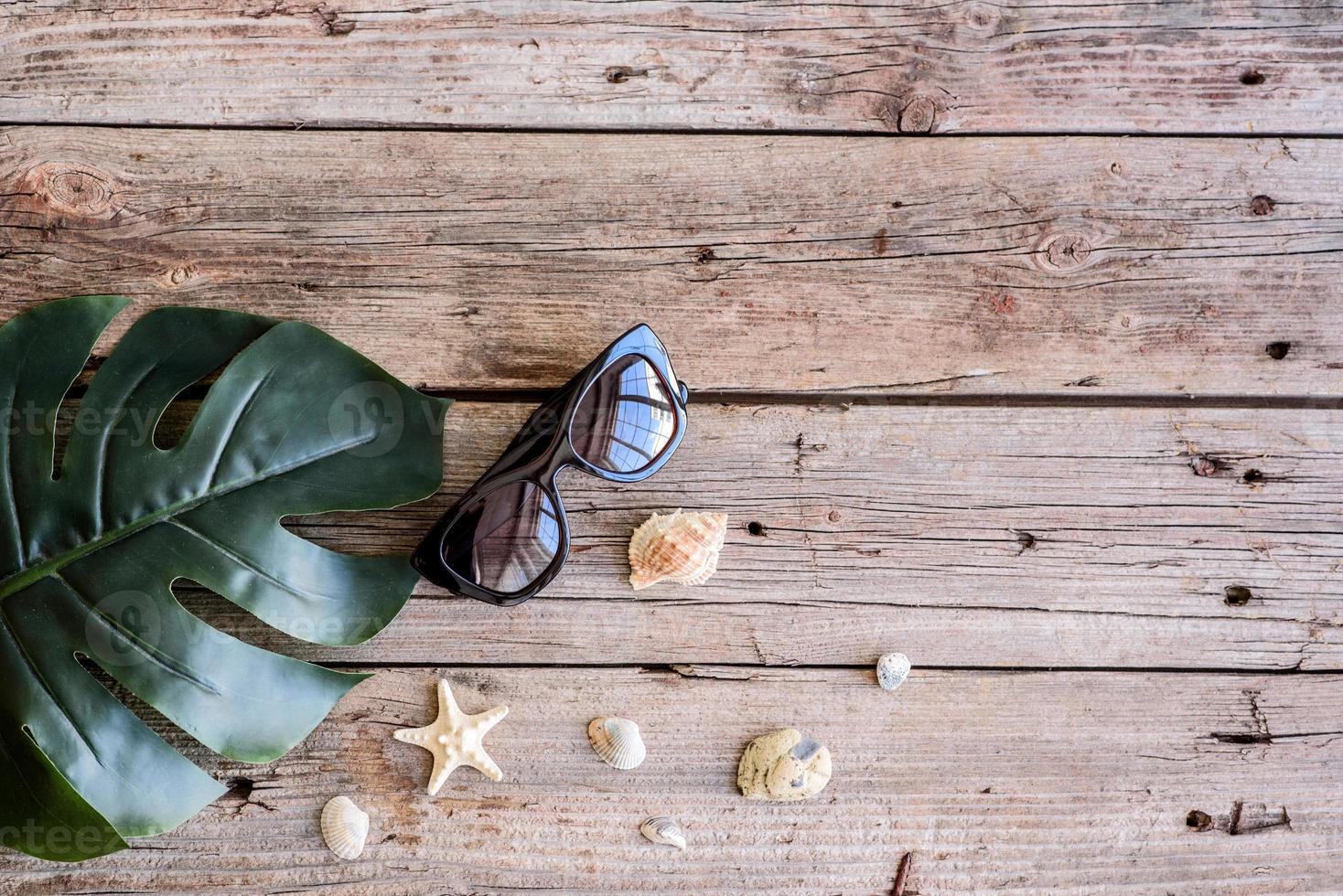 Glasses and hat with shells and sea stars on a colored background photo