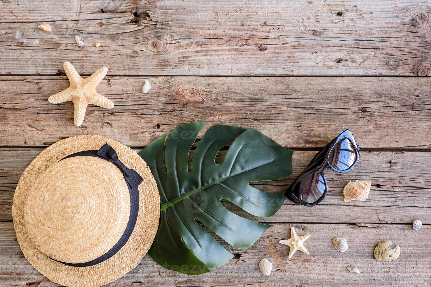 Glasses and hat with shells and sea stars on a colored background photo