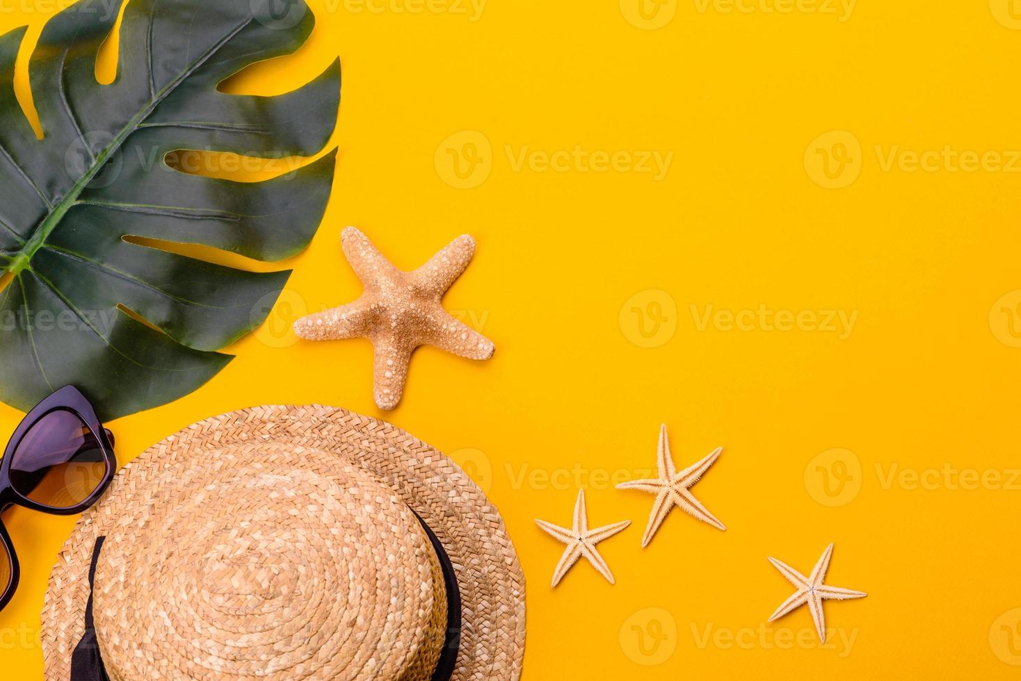Glasses and hat with shells and sea stars on a colored background photo