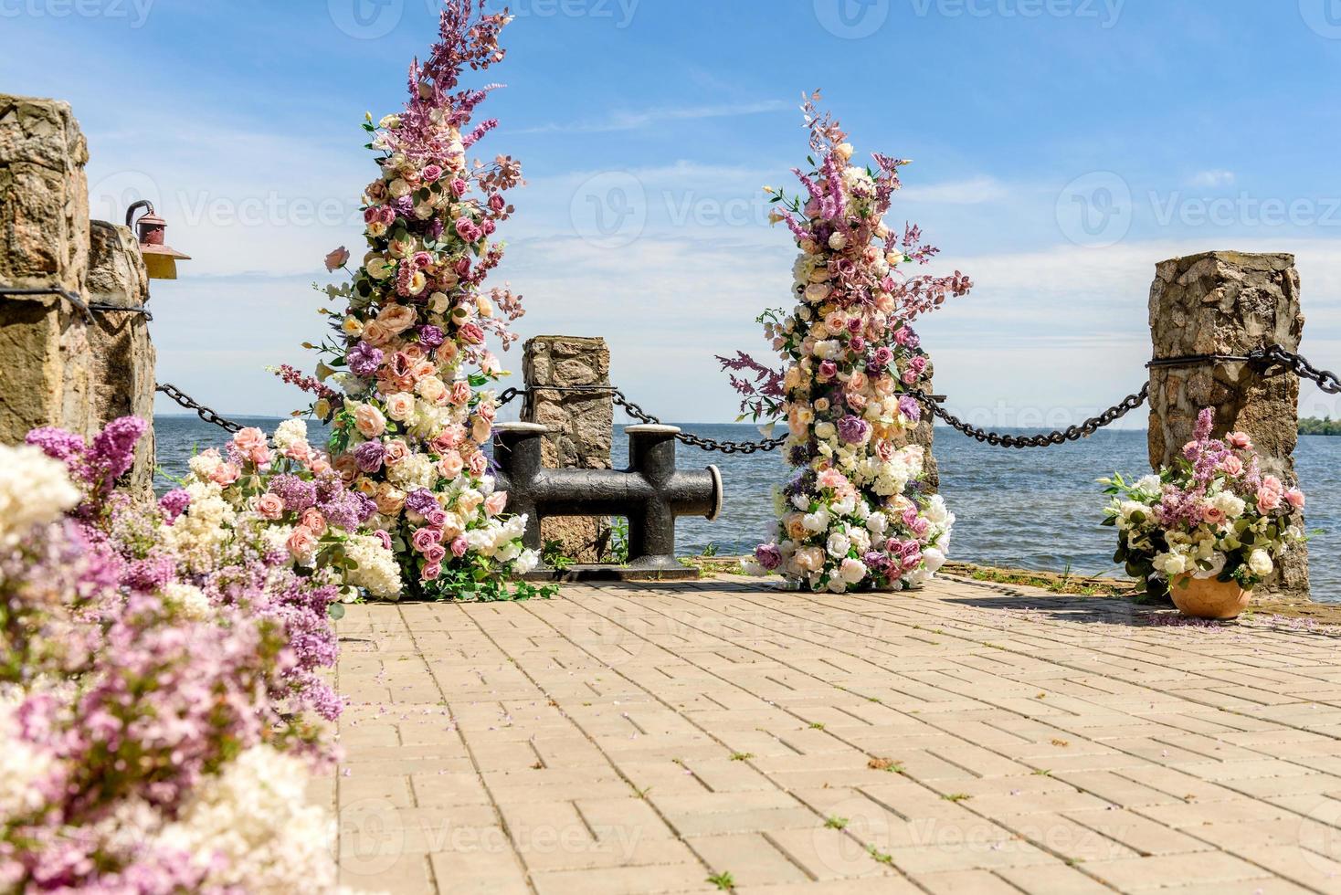 hermosa composición floral para una ceremonia de boda en la costa del océano foto