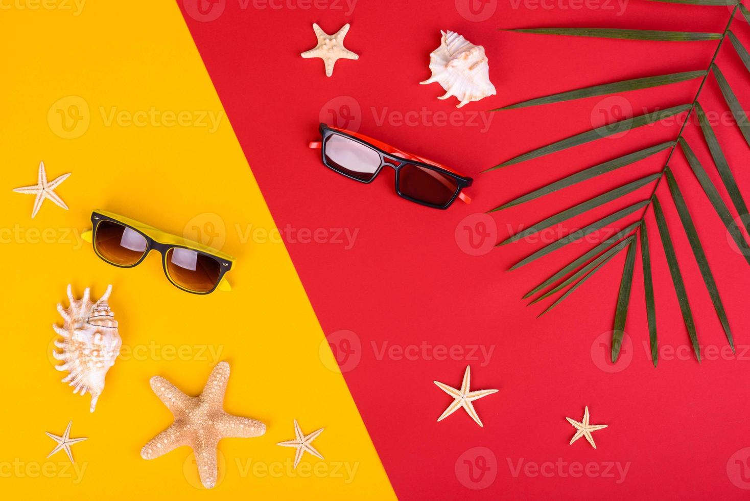 Glasses and hat with shells and sea stars on a colored background photo