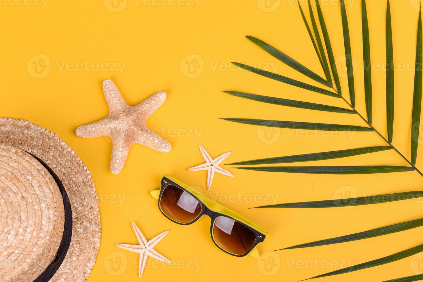 Glasses and hat with shells and sea stars on a colored background photo