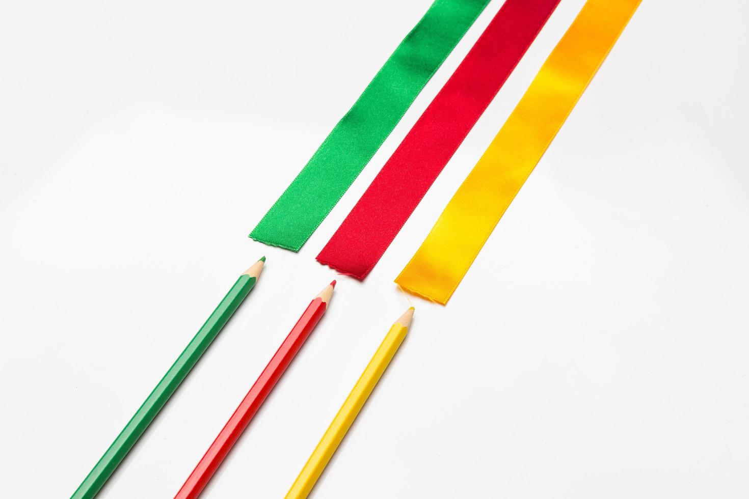 Coloured pencils wrapped in a green ribbon photo