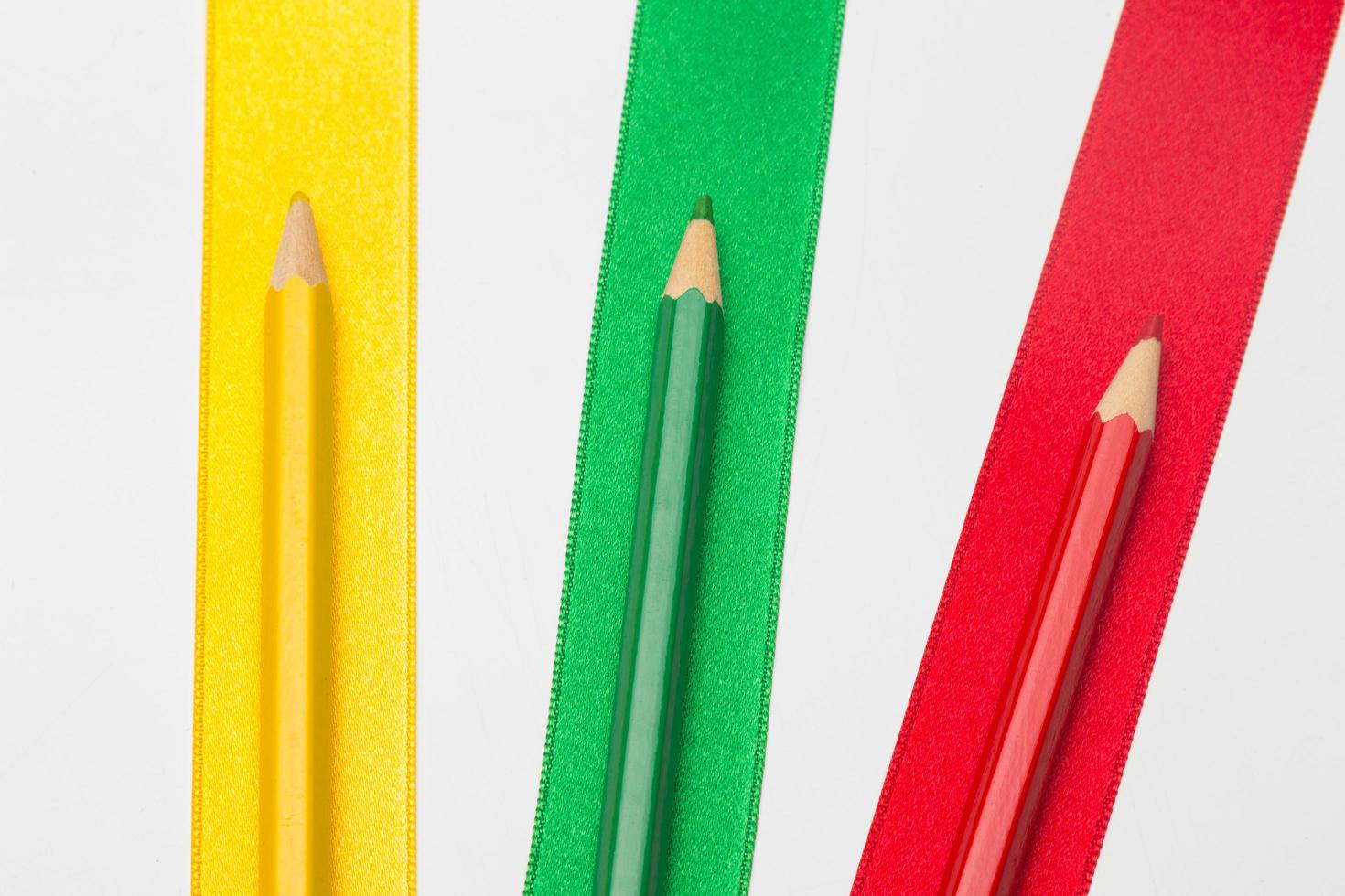 Coloured pencils wrapped in a green ribbon photo