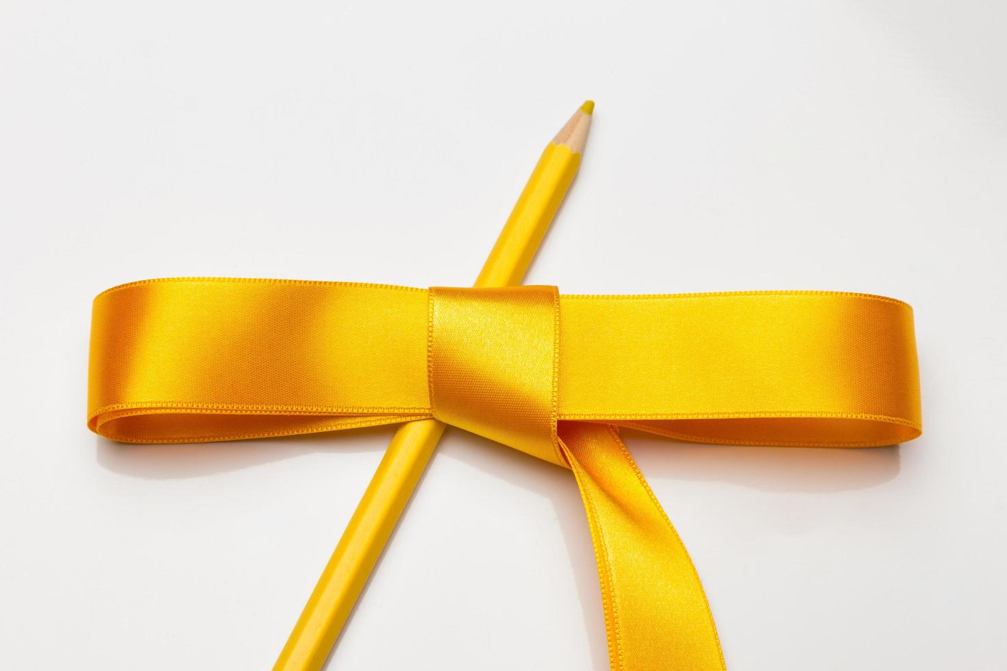 Coloured pencils wrapped in a green ribbon photo