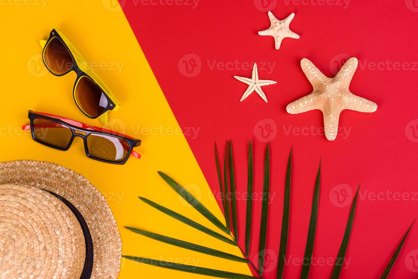 Glasses and hat with shells and sea stars on a colored background photo