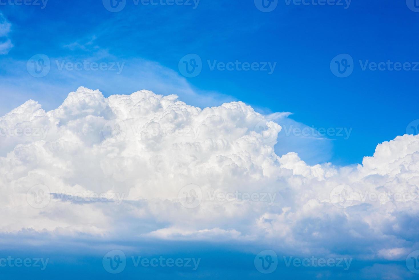 Beautiful white clouds in a bright blue sky on a warm summer day photo