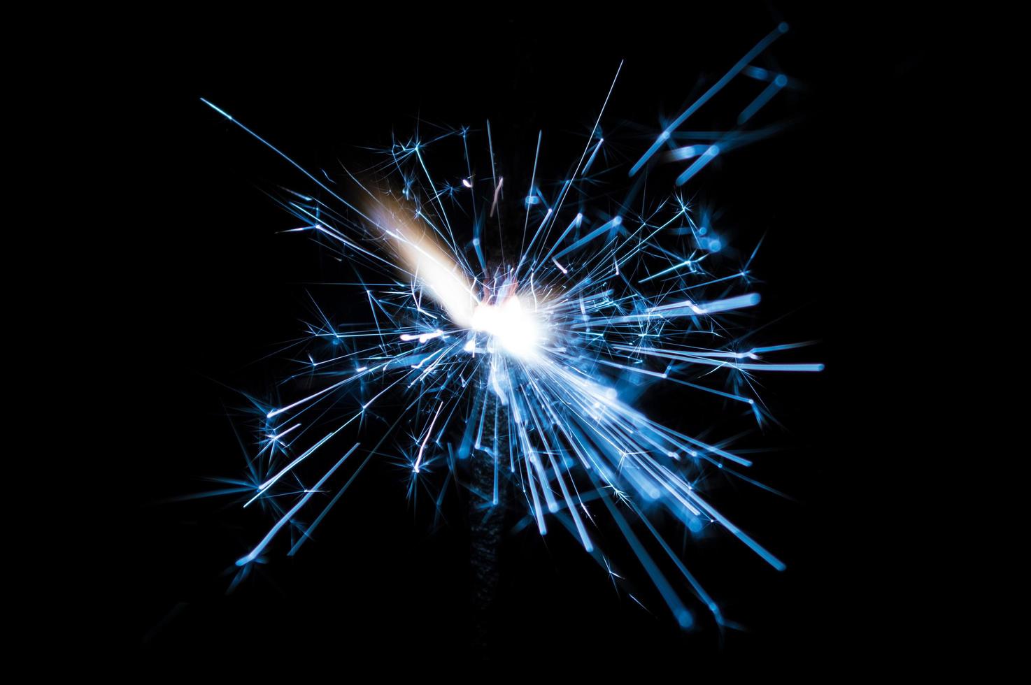 Sparkler in blue and white light on a black background photo