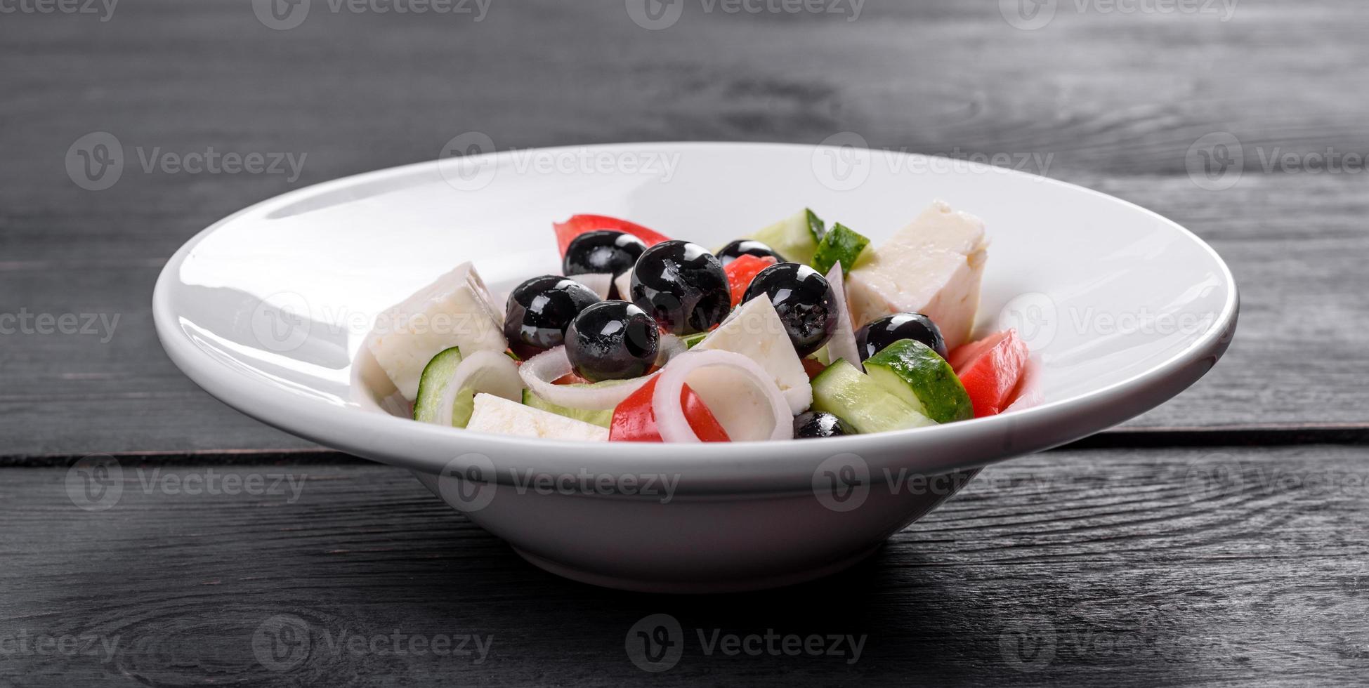 deliciosa ensalada griega fresca con tomate, pepino, cebolla y aceitunas con aceite de oliva foto