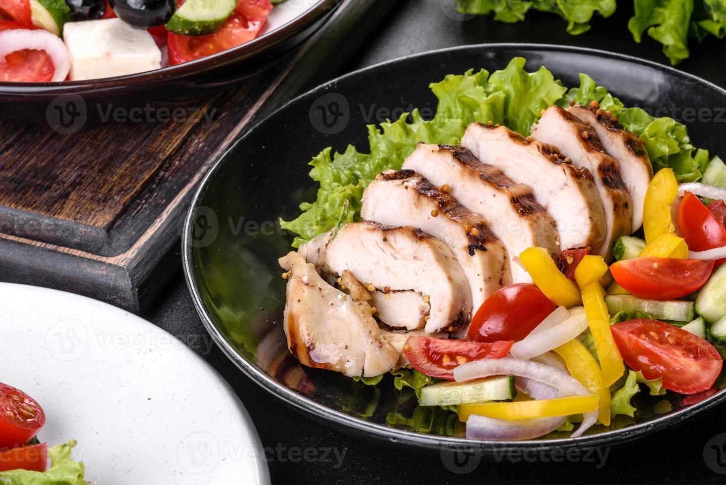 Fresh delicious salad with chicken, tomato, cucumber, onions and greens with olive oil photo