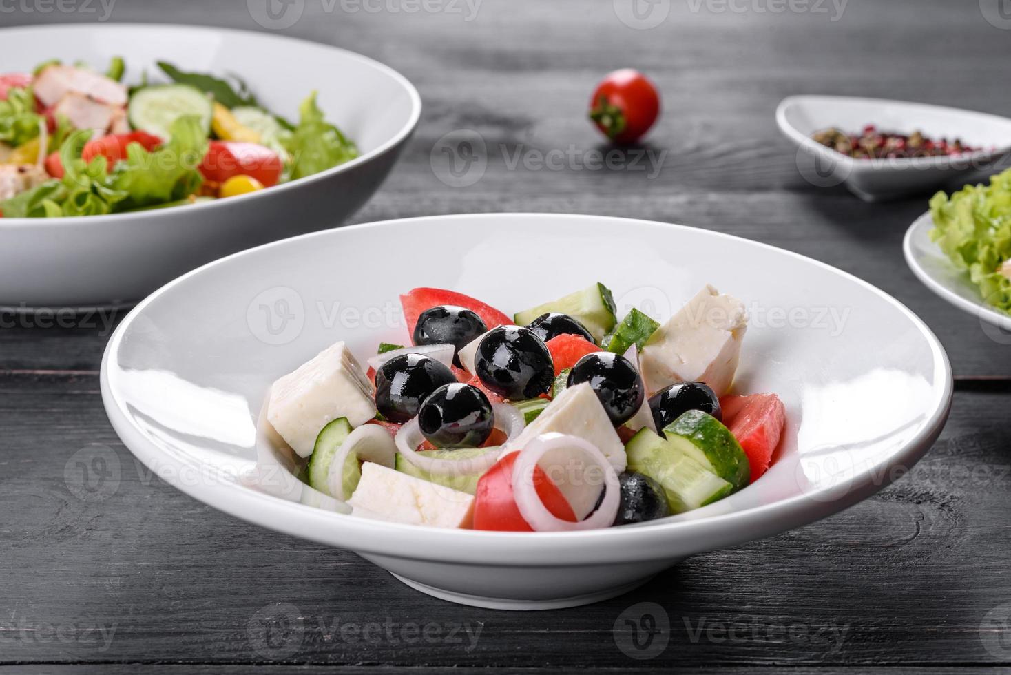 deliciosa ensalada griega fresca con tomate, pepino, cebolla y aceitunas con aceite de oliva foto