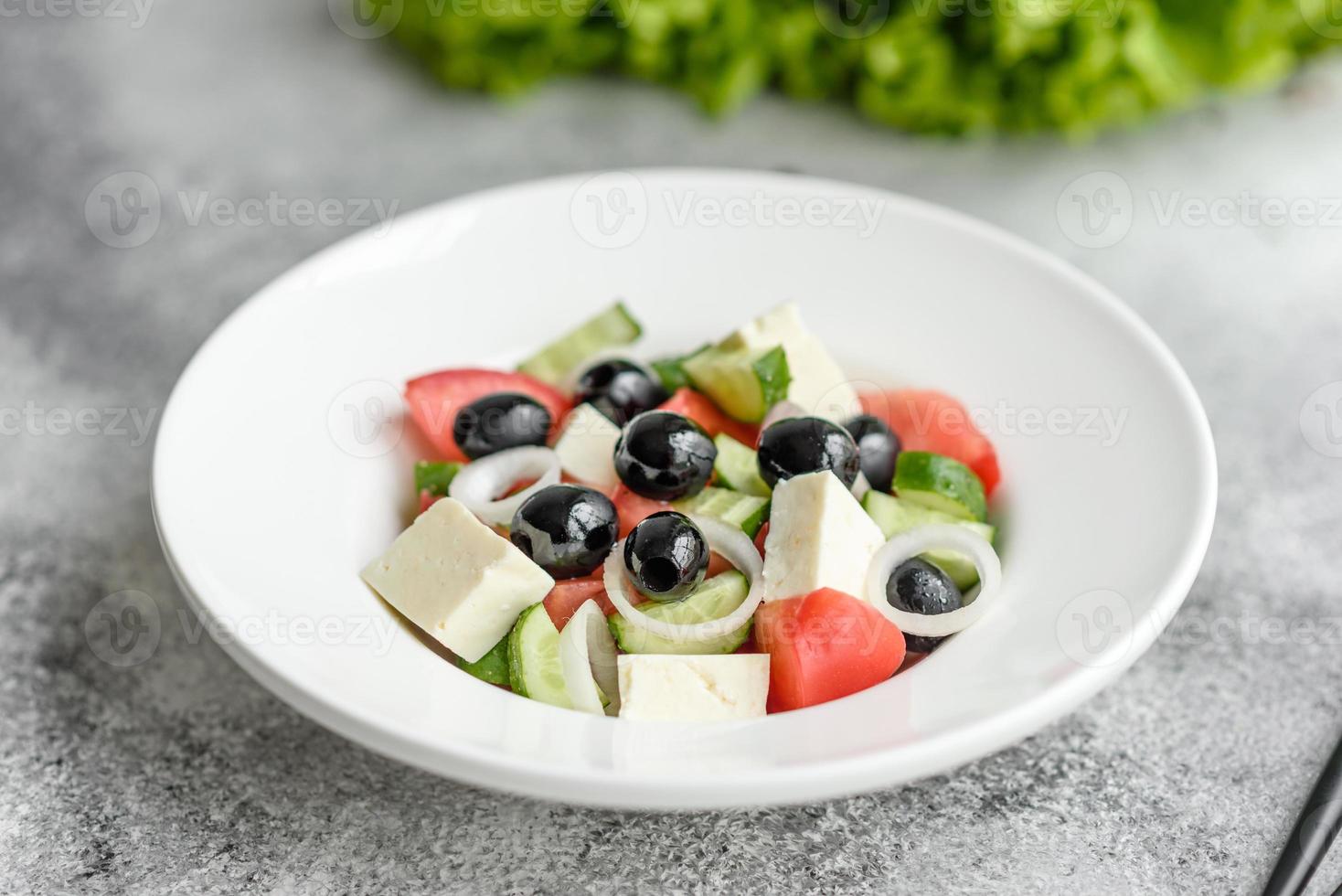 deliciosa ensalada griega fresca con tomate, pepino, cebolla y aceitunas con aceite de oliva foto